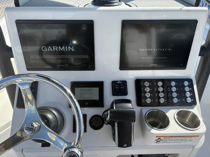  Yacht Photos Pics Control panel of 2023 Caymas 28 HB boat with Garmin displays and steering wheel.