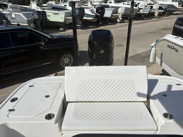  Yacht Photos Pics 2023 Caymas 28 HB boat with white seating and powerful outboard motor in a marina.