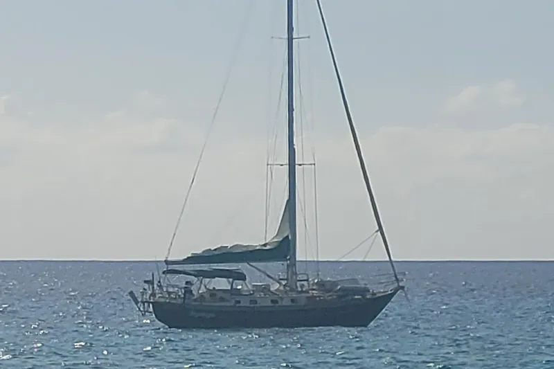 Lagniappe Yacht Photos Pics Sailboat on calm sea, Pacific Seacraft Crealock 44, 1990 model.