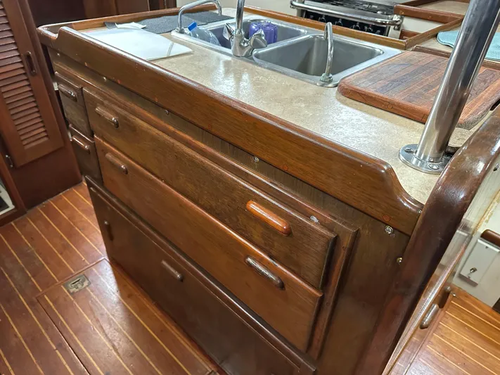 Lagniappe Yacht Photos Pics Interior of 1990 Pacific Seacraft Crealock 44 yacht, featuring wooden cabinetry and dual sink.