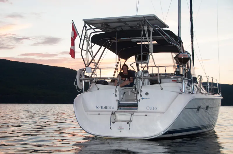 Inspiration VI Yacht Photos Pics 2006 Hunter 41 sailboat on calm water at sunset with a Canadian flag.