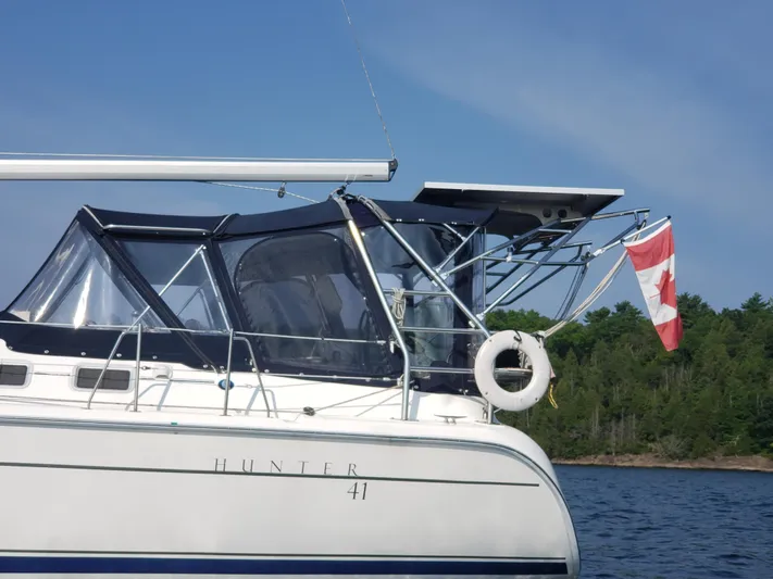 Inspiration VI Yacht Photos Pics 2006 Hunter 41 sailboat with Canadian flag on a calm lake.