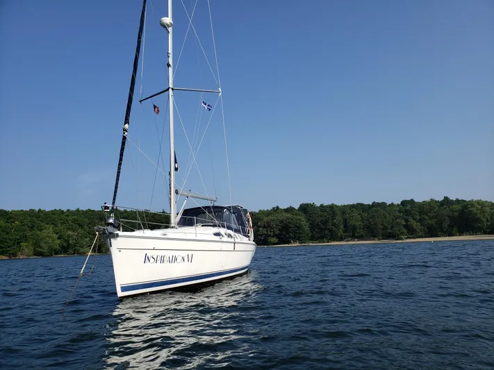 Inspiration VI Yacht Photos Pics 2006 Hunter 41 sailboat on calm water near a forested shoreline.