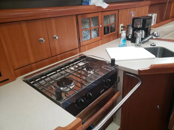 Inspiration VI Yacht Photos Pics 2006 Hunter 41 yacht kitchen with stove, sink, and wooden cabinetry.