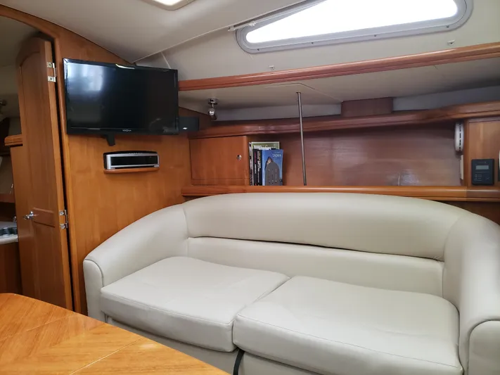 Inspiration VI Yacht Photos Pics Interior of 2006 Hunter 41 yacht with beige sofa and mounted TV.