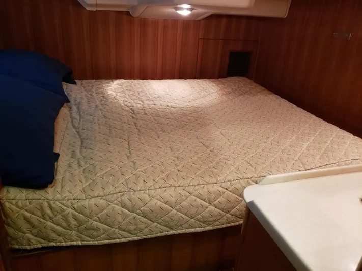 Inspiration VI Yacht Photos Pics Cozy cabin bed in 2006 Hunter 41 sailboat with quilted bedding and wooden paneling.