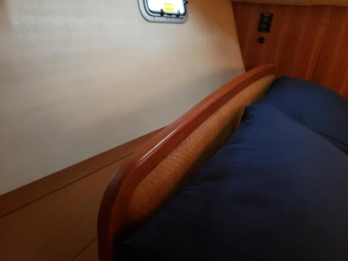 Inspiration VI Yacht Photos Pics Interior cabin of a 2006 Hunter 41 sailboat with wooden paneling and a small window.