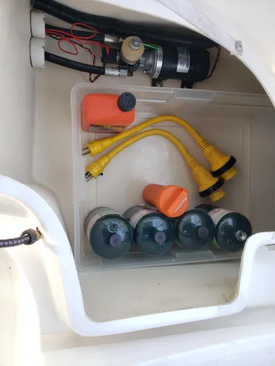 Inspiration VI Yacht Photos Pics Storage compartment in a 2006 Hunter 41 boat with cables and bottles.