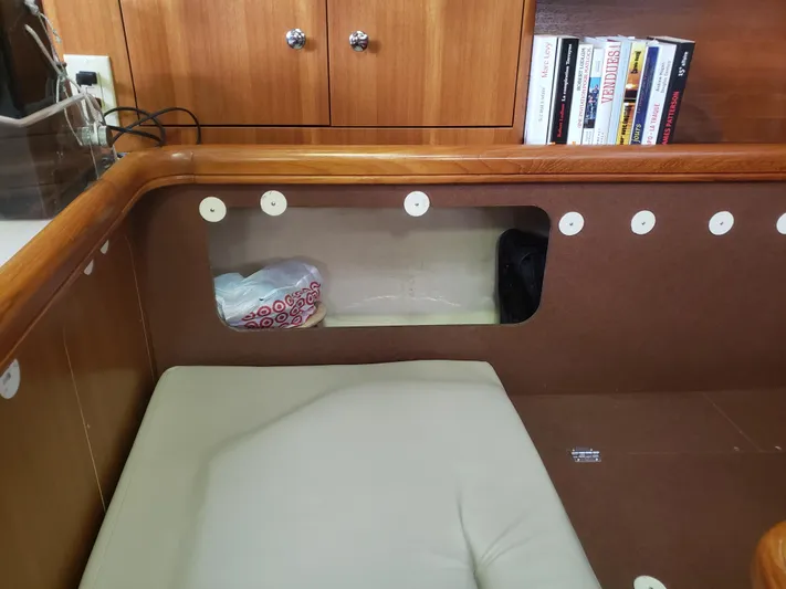 Inspiration VI Yacht Photos Pics Interior of a 2006 Hunter 41 sailboat with seating, storage, and books.