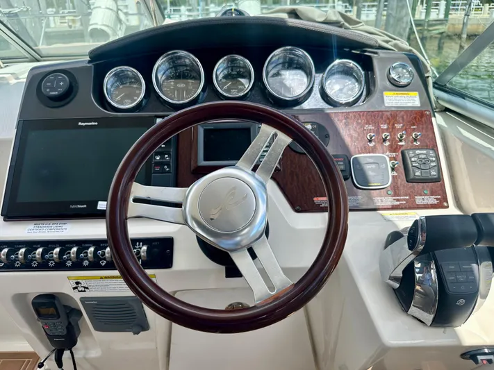  Yacht Photos Pics Cockpit of 2012 Sea Ray 310 Sundancer with steering wheel and control panel.