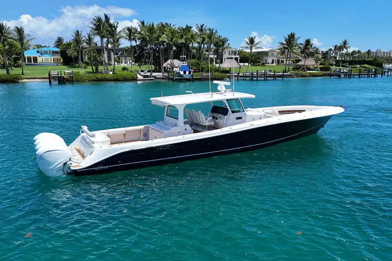  Yacht Photos Pics 2020 HCB 53 Sueños boat on clear blue water near a tropical shoreline.