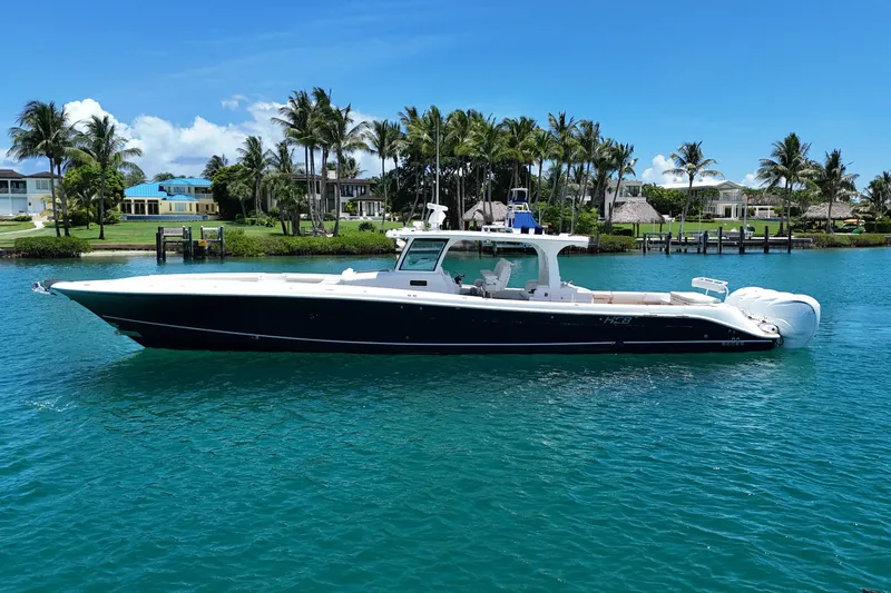  Yacht Photos Pics 2020 HCB 53 Sueños boat cruising on clear blue water near palm trees.