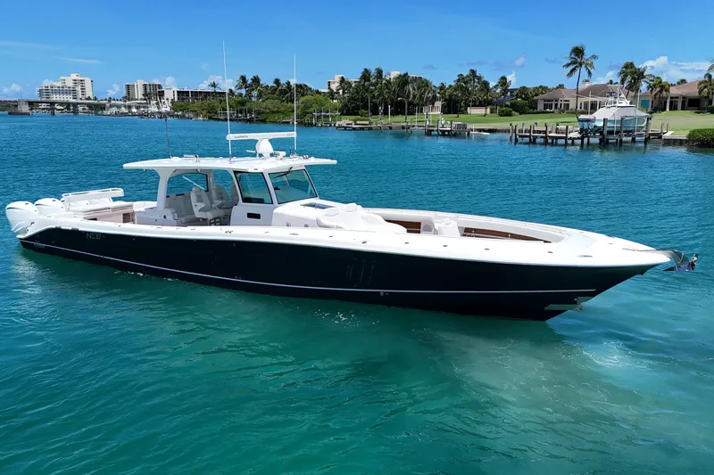  Yacht Photos Pics 2020 HCB 53 Sueños luxury boat on clear blue water, near a tropical shoreline.