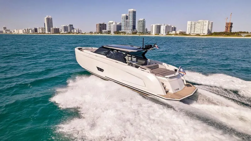 The Next Trade Yacht Photos Pics 2022 Vanquish Yachts VQ58 cruising on ocean near city skyline.