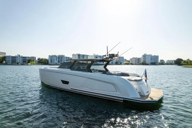 The Next Trade Yacht Photos Pics 2022 Vanquish Yachts VQ58 on water, modern design, cityscape background.