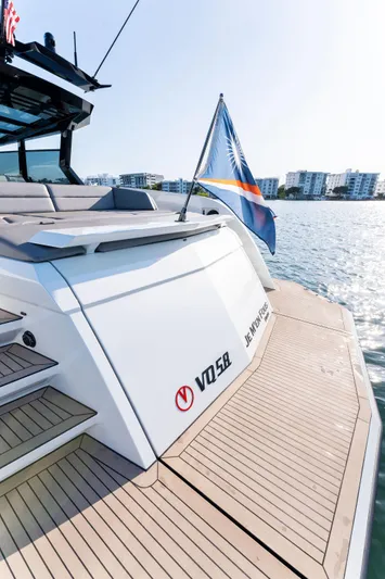 The Next Trade Yacht Photos Pics 2022 Vanquish Yachts VQ58 on water, rear view with flag, modern design.