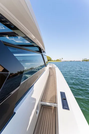 The Next Trade Yacht Photos Pics 2022 Vanquish Yachts VQ58, sleek design, cruising on open water under clear blue sky.