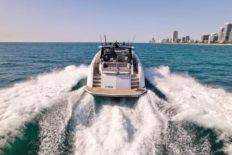 The Next Trade Yacht Photos Pics Vanquish Yachts VQ58 2022 cruising on ocean near city skyline.