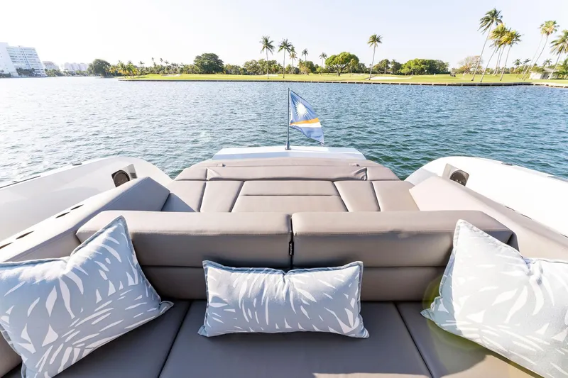 The Next Trade Yacht Photos Pics Luxurious 2022 Vanquish Yachts VQ58 with plush seating, scenic water view, and decorative cushions.