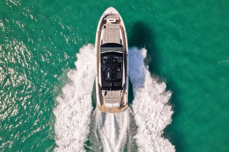 The Next Trade Yacht Photos Pics Aerial view of 2022 Vanquish Yachts VQ58 cruising on turquoise water.