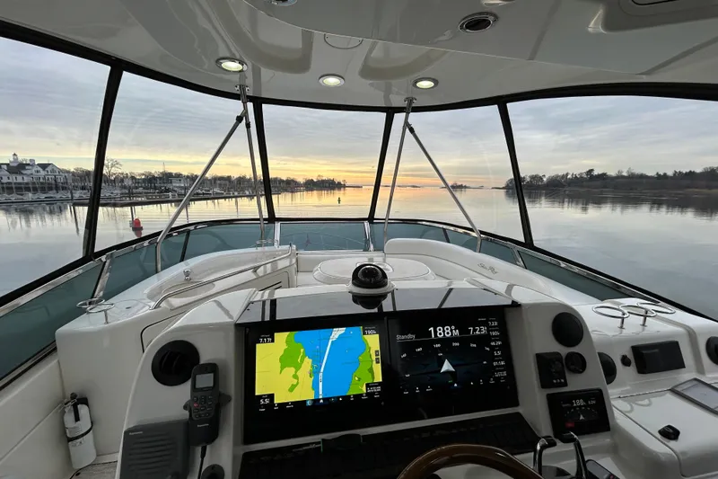  Yacht Photos Pics 2008 Sea Ray 52 Sedan Bridge helm with navigation screens, overlooking serene waters at sunset.