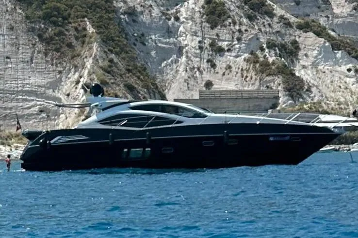  Yacht Photos Pics 2009 Sunseeker Predator 64 yacht cruising near rocky cliffs.