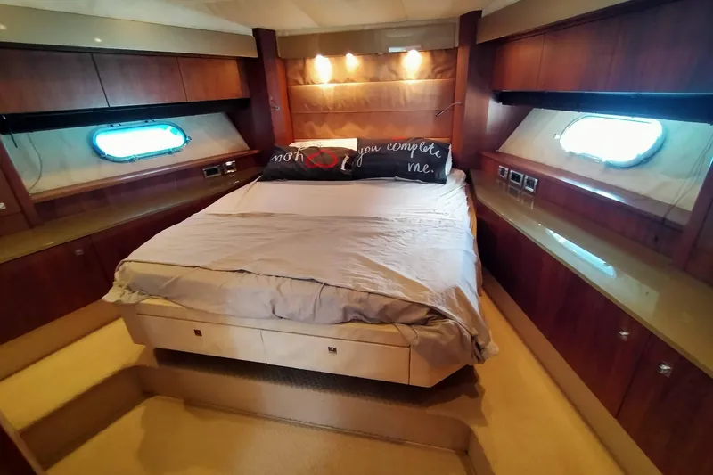  Yacht Photos Pics Luxurious bedroom interior of 2009 Sunseeker Predator 64 yacht with elegant wood finishes.
