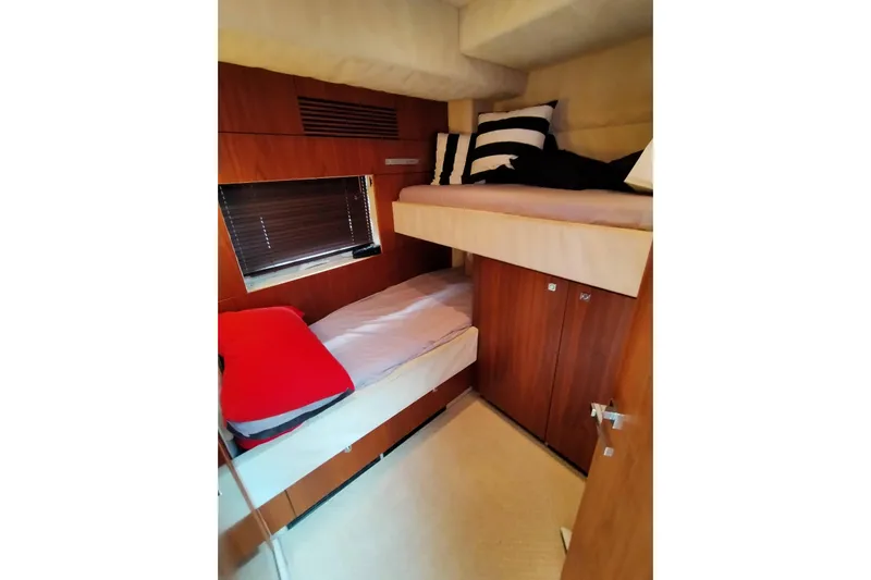  Yacht Photos Pics Interior cabin of 2009 Sunseeker Predator 64 yacht with bunk beds and wooden finish.