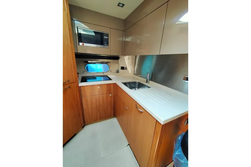  Yacht Photos Pics Modern kitchen in 2009 Sunseeker Predator 64 yacht with wood cabinets and stainless steel appliances.