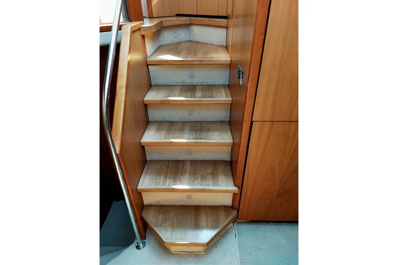  Yacht Photos Pics Wooden staircase inside 2009 Sunseeker Predator 64 yacht, featuring sleek handrail and carpeted steps.
