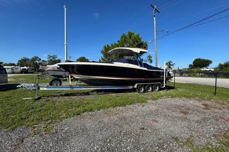  Yacht Photos Pics 2018 Chris-Craft Calypso 30 boat on a trailer, parked outdoors under clear blue sky.