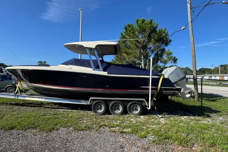  Yacht Photos Pics 2018 Chris-Craft Calypso 30 boat on trailer, parked outdoors under clear blue sky.