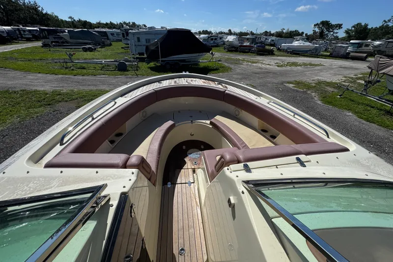  Yacht Photos Pics 2018 Chris-Craft Calypso 30 boat with spacious seating and wooden deck, parked outdoors.