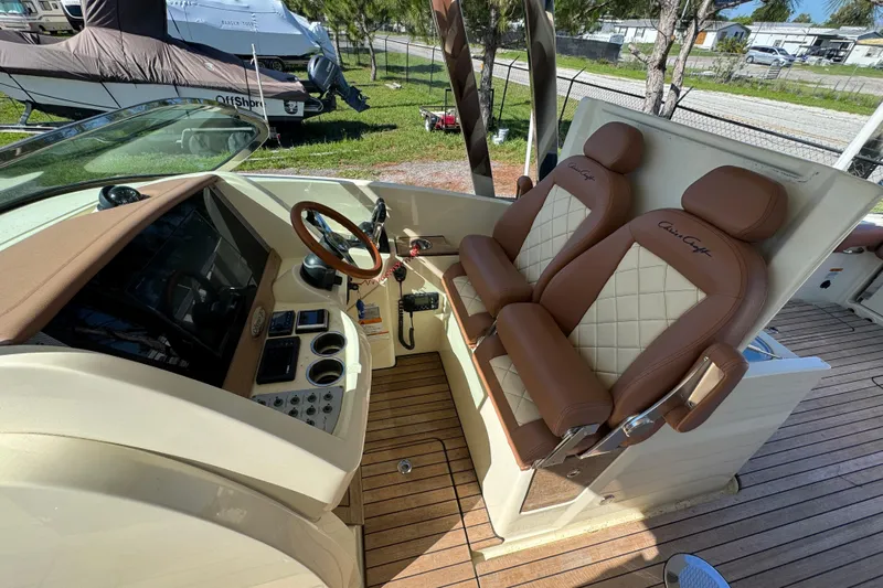 Yacht Photos Pics 2018 Chris-Craft Calypso 30 helm with dual brown leather seats and wooden steering wheel.