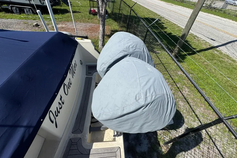  Yacht Photos Pics 2018 Chris-Craft Calypso 30 boat with covered engines, parked near a fence.