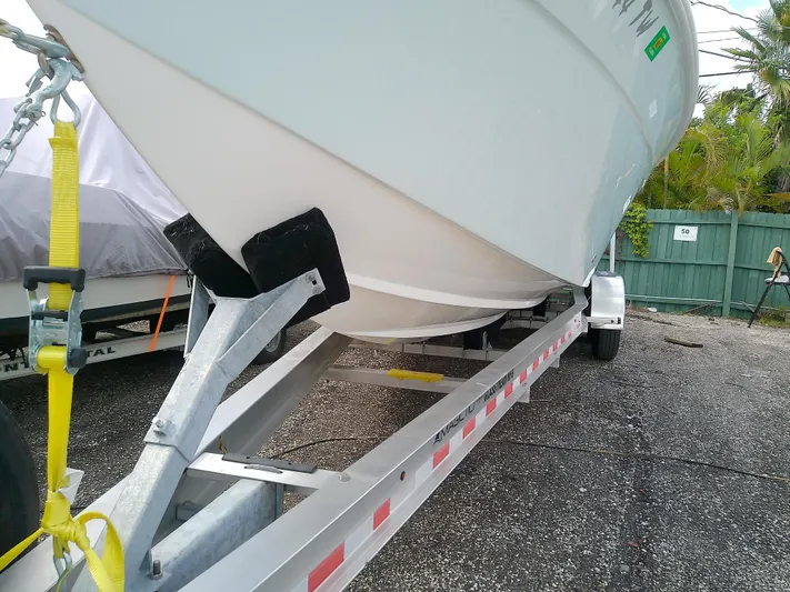  Yacht Photos Pics 2025 Glasstream 328 SCX boat on trailer, secured with yellow strap, parked outdoors.