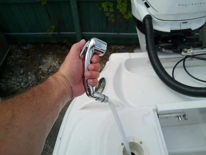  Yacht Photos Pics Hand holding a chrome faucet on a 2025 Glasstream 328 SCX boat.