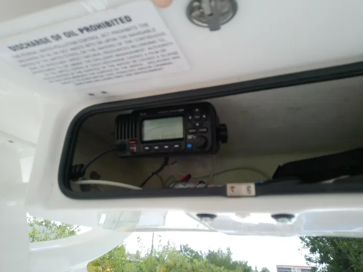  Yacht Photos Pics 2025 Glasstream 328 SCX boat radio compartment with oil discharge warning sign.