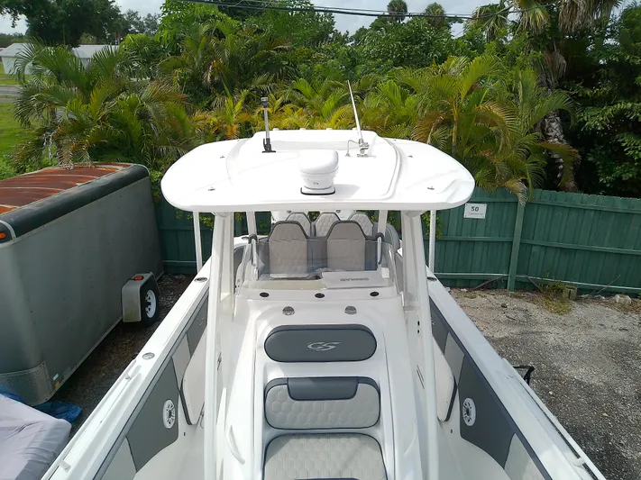  Yacht Photos Pics 2025 Glasstream 328 SCX boat with sleek design, parked near lush greenery.