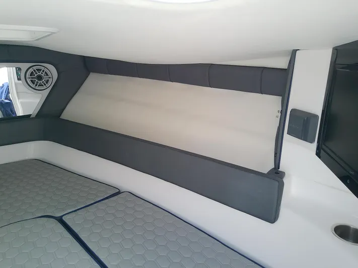  Yacht Photos Pics Interior cabin of 2025 Glasstream 328 SCX boat, featuring cushioned seating and speaker.