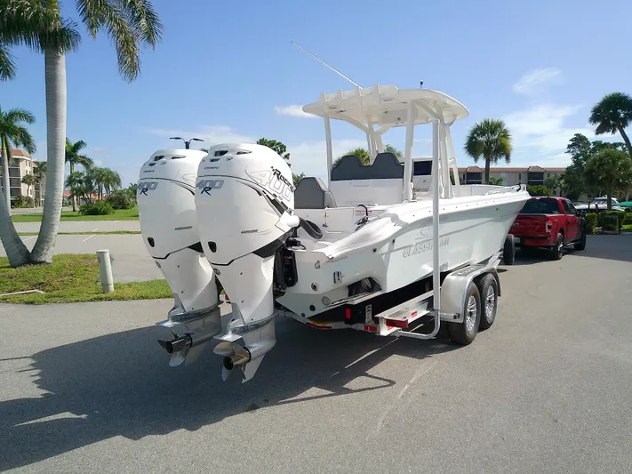  Yacht Photos Pics 2025 Glasstream 328 SCX boat on trailer with dual outboard motors, parked near palm trees.