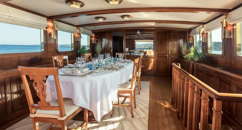Le Kir Royal Yacht Photos Pics Luxurious dining area on 1966 Van den Akker Le Kir Royal yacht, featuring elegant wooden interiors.