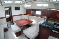 Luxurious interior of 2017 Hanse 455 yacht with modern seating and kitchen area.