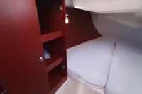 Cabin interior of 2017 Hanse 455 yacht with wooden storage and cozy bed.