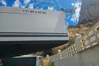 Hanse 455 sailboat from 2017, docked with rocky cliff background under blue sky.