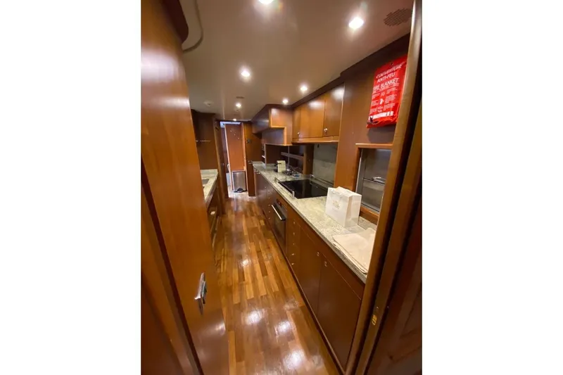  Yacht Photos Pics Luxurious kitchen interior on 2004 Benetti Tradition 100 yacht with wooden cabinetry and modern appliances.