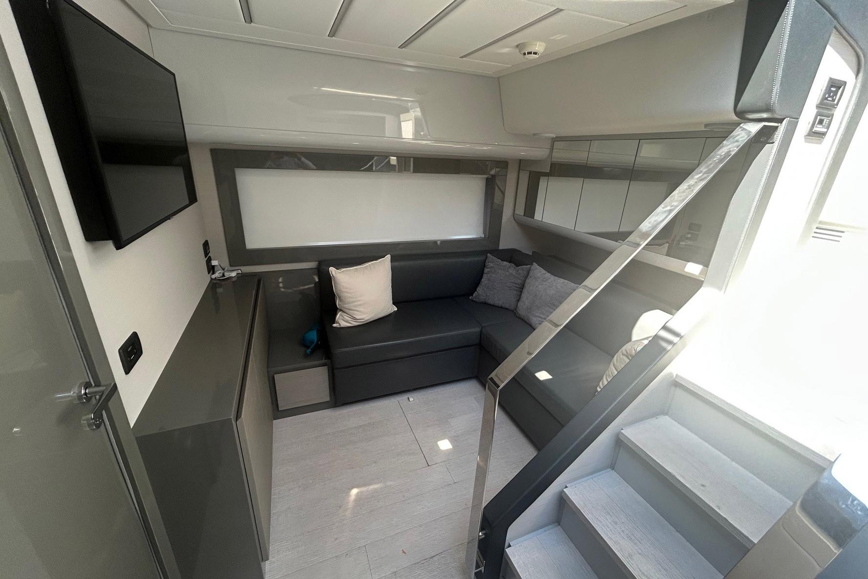 Modern interior of 2020 Pershing 62 yacht with sleek seating and TV.