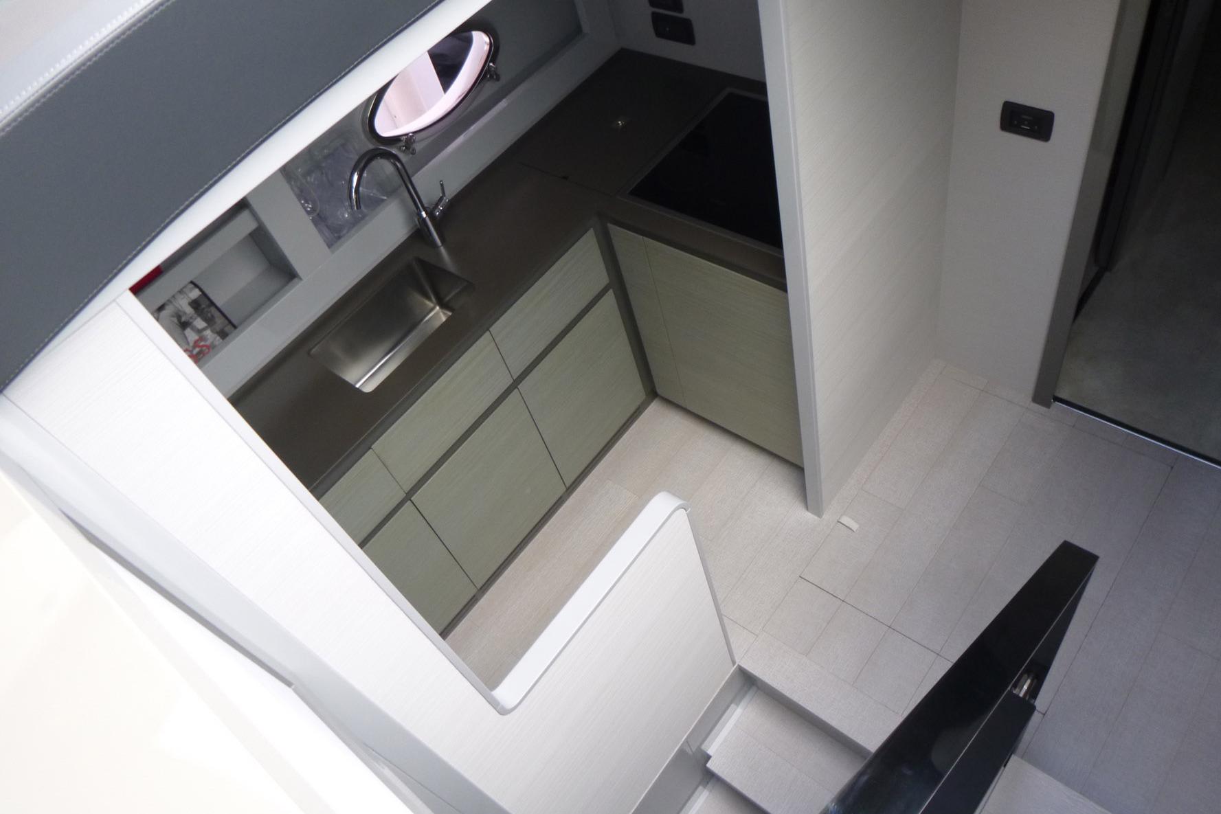 Modern kitchen interior on a 2020 Pershing 62 yacht, featuring sleek cabinetry and stainless steel sink.