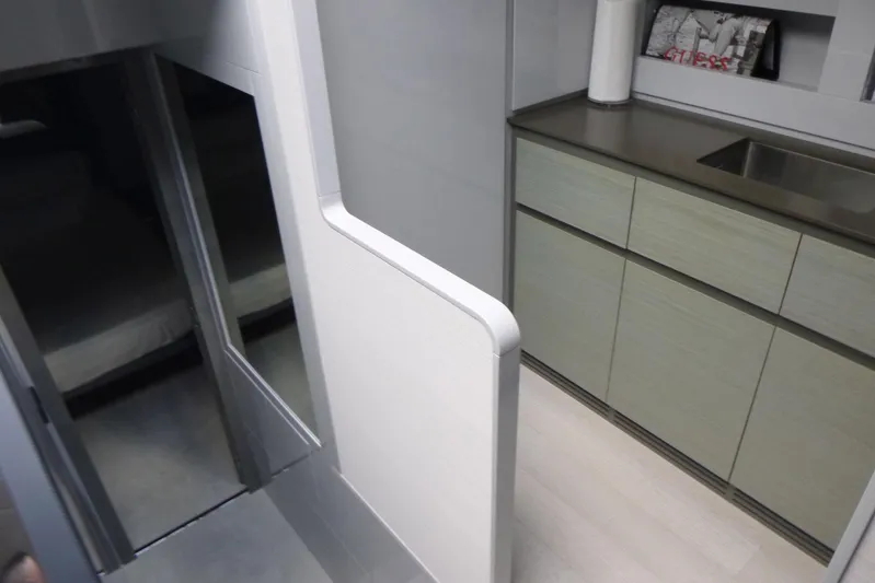 Habeas Orcas Yacht Photos Pics Modern interior of a 2020 Pershing 62 yacht, featuring sleek cabinetry and a compact sink area.