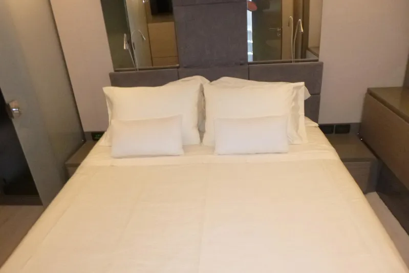 Habeas Orcas Yacht Photos Pics Luxurious bedroom interior on a 2020 Pershing 62 yacht, featuring a neatly made bed.